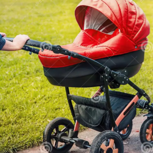 Red stroller being pushed in a park