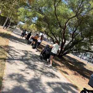 A paved path with people pushing strollers